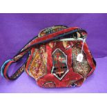 A Carpet Bags shoulder bag in shades of red and amber