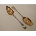 A pair of Georgian silver berry spoons having silver gilt bowls and bright cut engraving to stems,