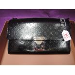 A black leather clutch bag stamped Louis Vuitton having embossed decoration to leather, metal clasp,