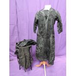 An early 20th century lady's black silk mourning dress having bead and net decoration to front, a