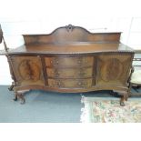 An early 20th century mahogany Chippendale revival sideboard having raised back and serpentine front