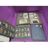 A collection in four albums of postcards and cigarette cards including real photo cards and Sinn