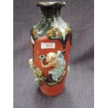 An early 20th century pottery vase in the Oriental style having drip glaze and Oriental figure