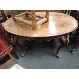 A late 19th century mahogany centre table of French style, having oval top with carved apron on