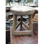 An early 20th century elm stool of Arts & Craft design having circular top on triform base, having