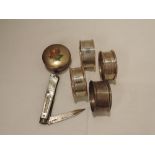 Four HM silver napkin rings, a folding fruit knife with HM silver blade and a white metal trinket