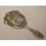 An Edwardian silver hand mirror having moulded decoration depicting a nymph standing on lily flowers