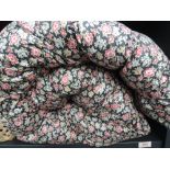 A double bed quilted eiderdown having floral print decoration on black ground