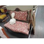 A late Victorian mahogany salon settee having carved crest with later upholstery back and seat, on