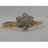 A lady's dress ring having a diamond daisy swirl cluster on a 9ct gold loop, size M