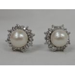 A pair of cultured pearl stud earrings having diamond surrounds, approx 0.8ct in white metal