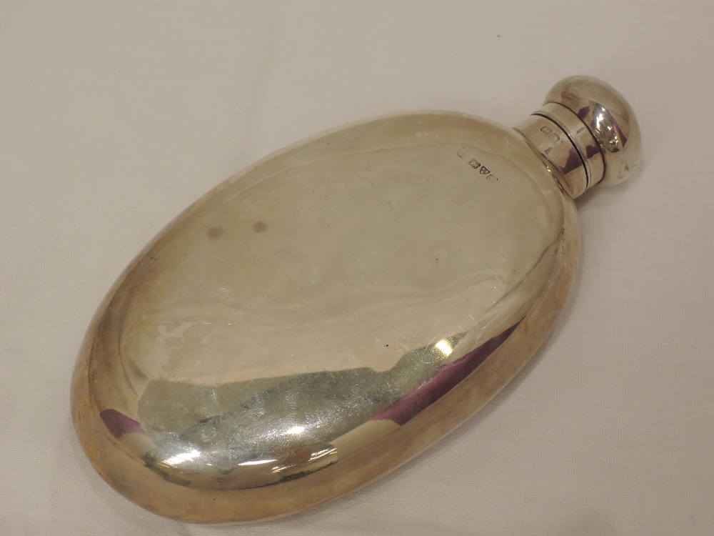 A silver hip flask of plain oval form, Chester 1912, makers mark worn