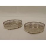 A pair of miniature silver oval coasters having gallery rims and bun feet, Birmingham 1977, makers