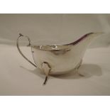 A silver sauce boat of plain form having loop handle and trefoil paw feet, Sheffield 1933, Lee &