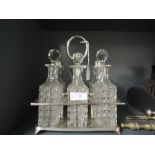 A six bottle pressed glass cruet in a plated tray