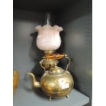 A brass oil lamp with glass shade and a brass kettle