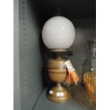 A vintage oil lamp with a milk glass globe