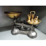 A vintage balance scale set and graduated brass weights