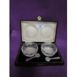 A cased pair of cut glass salts having mother of pearl spoons