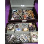 A jewellery box containing a selection of costume jewellery brooches, watches etc