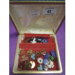 A small jewellery case containing a selection of Girl Guide badges etc