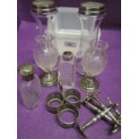 Six glass bottles and cut glass vases having HM silver collars, stands and lids, an HM silver bottle