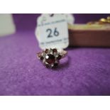 A lady's dress ring having a cubic zirconia and garnet cluster on a 9ct gold loop