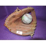 A vintage leather baseball / softball glove and ball