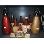 A selection of vintage ceramic Whiskey decanters and soda syphons