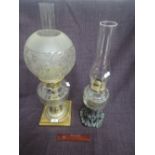 An early 20th century oil lamp having clear ribbed glass reservoir, on brass base and with later