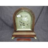 An early 20th century mahogany frame mantel clock having arch case and silvered dial with subsidiary