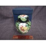 A Moorcroft lidded ginger jar in The Cavendish design with floral Camellia pattern on black