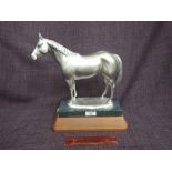 A modern cast figure modelled as a silver coloured horse, by Mehl Lawson, on green marble and wodd