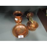 A selection of vintage copper wares including graduated measures and Celtic style dish