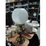 a vintage brass bodied electric lamp with milk glass shade