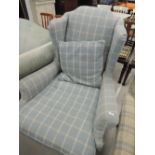 An early 20th Century wingback armchair having later blue tweed upholstery