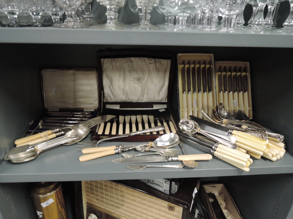 A selection of vintage cutlery flatware and canteen with bone effect handles