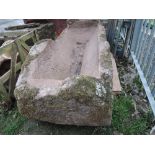 A rough hewn sandstone trough