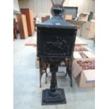 A vintage cast iron letter box with horse rider design