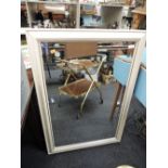 A modern cream frame wall mirror