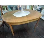 A vintage teak effect extending oval dining table