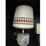 A vintage 70's style plaster cast lamp base with cave men scene