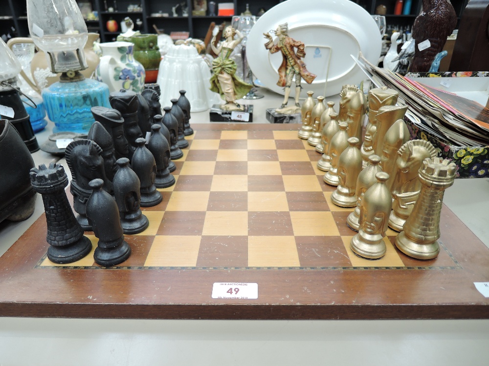 A vintage chess set with wood board and black and gold pieces