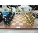 A vintage chess set with wood board and black and gold pieces