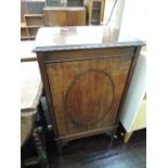 An Edwardian mahogany music cabinet having gadrooned rim with oval applique door and shelf