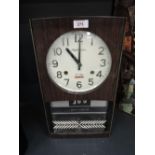 A vintage wall mounted day and date flip clock by Rhythm Gloria 60's design