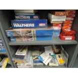 Two shelves of Walthers, Atlas, Muir Models and similar HO scale accessories kits including Modern