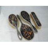 A four piece matched silver and tortoise shell dressing table brush and mirror set having silver