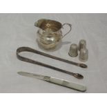 A small selection of HM silver and white metal including cream jug, thimbles, folding fruit knife