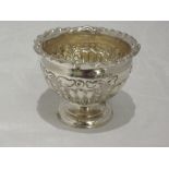 An Edwardian silver sugar bowl of urn form having repousse decoration and frilled rim with